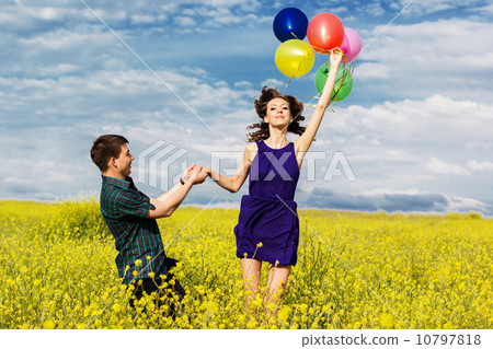 Happy couple with balloons on the yellow field Happy couple with balloons on the yellow field 10797818