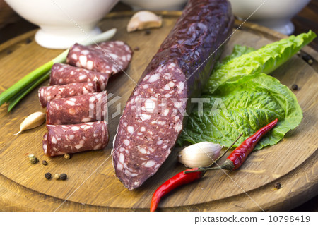 sausages on a wooden plate with vegetables in a restaurant 10798419