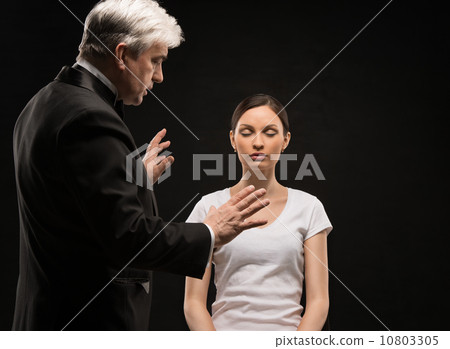 Alternative medicine therapist using hypnosis to heal his patien 10803305