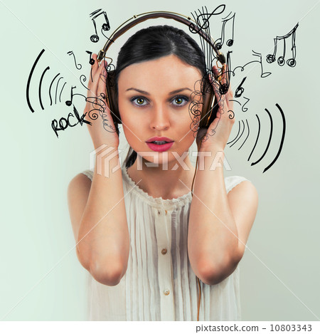 Girl with headphones on the grey background Girl with headphones on the grey background 10803343