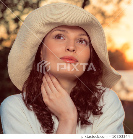 Young and beautiful woman wearing a hat in sunset light Young and beautiful woman wearing a hat in sunset light 10803344