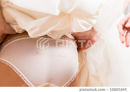 Woman showing panties during bridal gown fitting Woman showing panties during bridal gown fitting 10805845