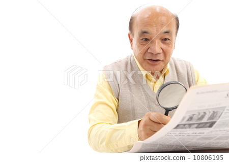 Senior viewing newspaper with magnifying glass Senior viewing newspaper with magnifying glass 10806195