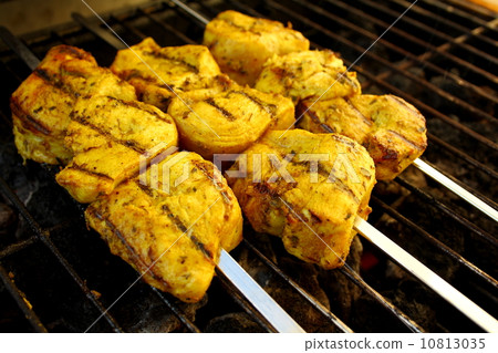 Chicken in curry sauce grilled on metal skewer 10813035