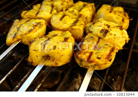 Chicken in curry sauce grilled on metal skewer 10813044