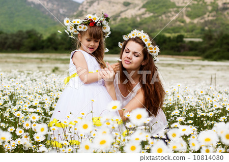 Mother with her child playing in camomile field 10814080