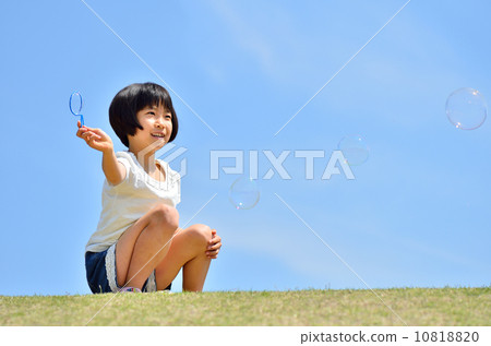 Girl playing soap bubble at lawn open space (blue sky) 10818820
