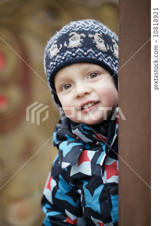 Cute little boy peering around a door Cute little boy peering around a door 10818921