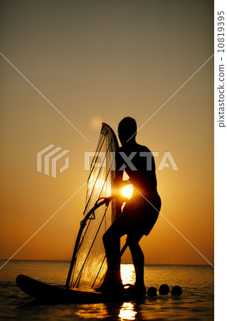 Man sailboarding at sunset 10819395