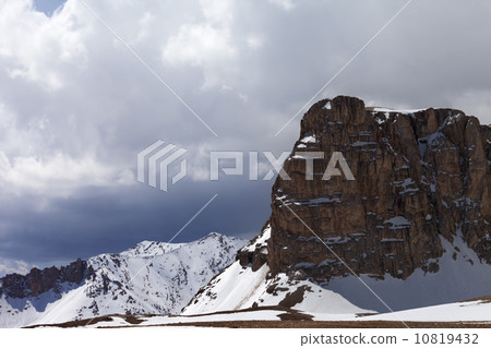 Snowy rocks and cloudy sky 10819432