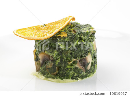 fried spinach decorated with a slice of orange 10819917