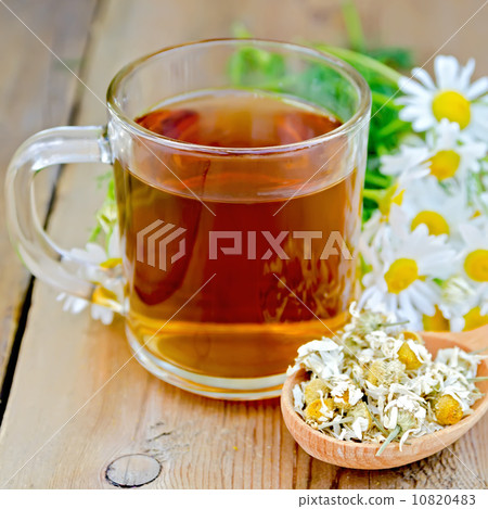 Herbal chamomile tea in glass mug on board Herbal chamomile tea in glass mug on board 10820483