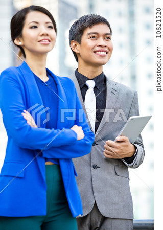 Female and male business executives looking ahead smiling Female and male business executives looking ahead smiling 10821520