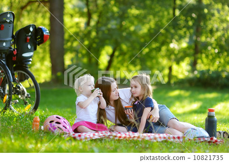 Young mother and her daughters having a picnic 10821735