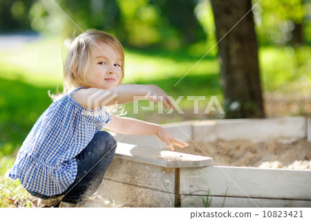 Adorable girl playing in a sandbox 10823421