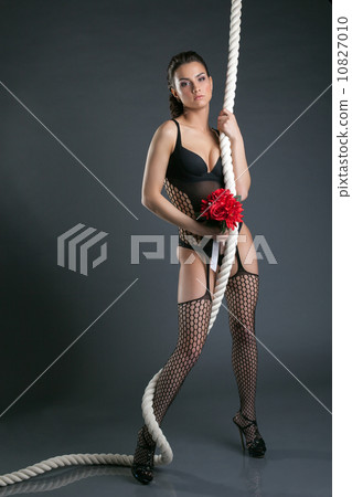 Attractive model posing with rope and bouquet Attractive model posing with rope and bouquet 10827010