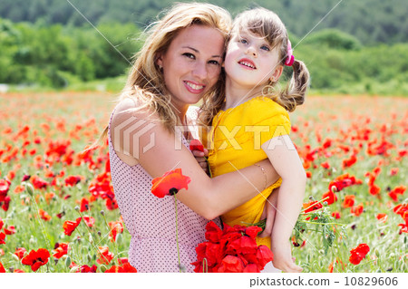 Mother playing with her child in poppy field 10829606