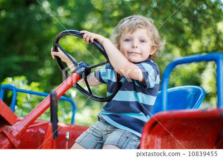 Portrait of little blond boy in tractor in summer Portrait of little blond boy in tractor in summer 10839455