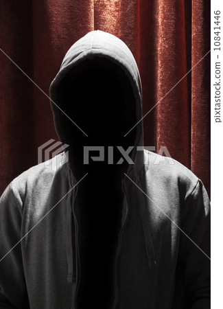Portrait of Invisible man in the hood with red curtain backgroun 10841446