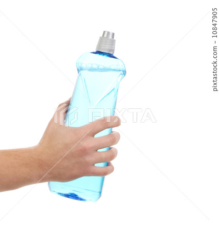 Hand in gloves holds detergent bottle. 10847905