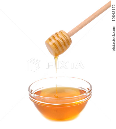 Honey dripping from a wooden dipper. Honey dripping from a wooden dipper. 10848172