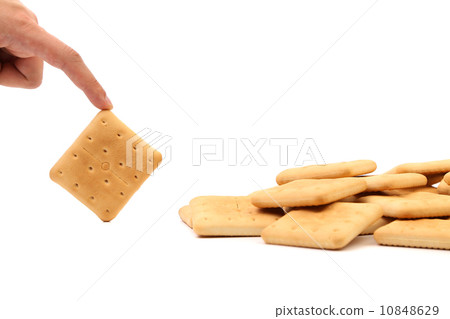Hand holds saltine soda cracker. Hand holds saltine soda cracker. 10848629