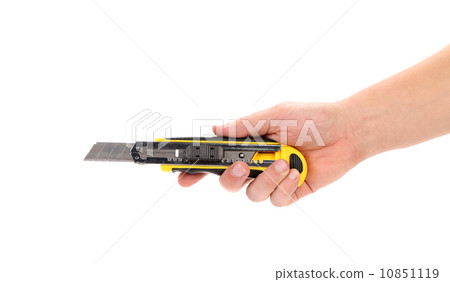 Hand holds yellow stationery knife 10851119