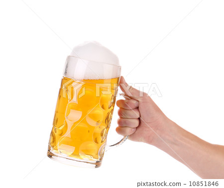Hand holds mug of fresh beer with foam. 10851846
