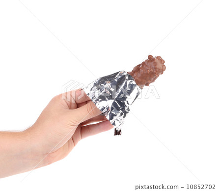 Hand holds bar chocolate in foil. Hand holds bar chocolate in foil. 10852702