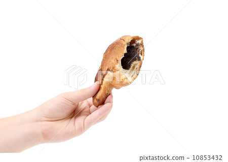 Hand holds bitten croissant with poppy. 10853432