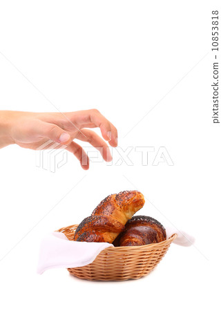 Hand reaching for croissants. 10853818