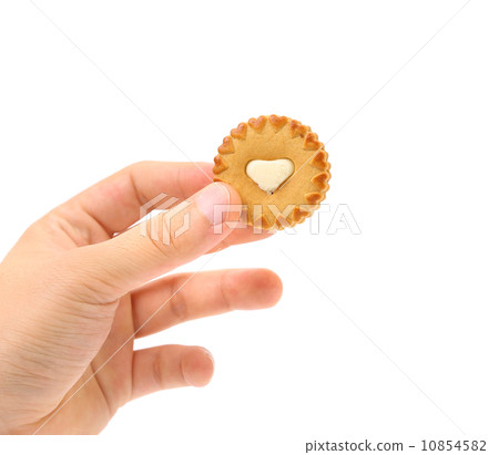 Hand holds biscuits with white heart. 10854582