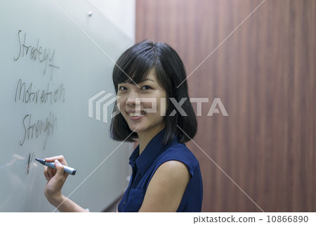A young chinese female executive preparing presentation on a white board 10866890
