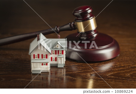 Gavel and Small Model House on Table 10869224