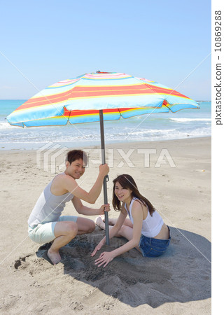年輕夫婦設置沙灘傘 年輕夫婦設置沙灘傘 10869288