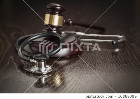 Gavel and Stethoscope on Reflective Table 10869399