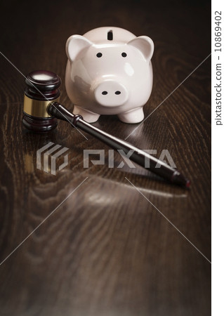 Gavel and Piggy Bank on Table 10869402