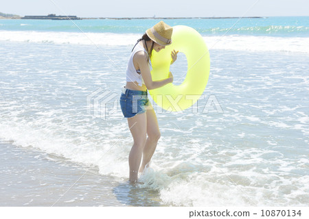 A young lady holding a float and playing at the beach 10870134