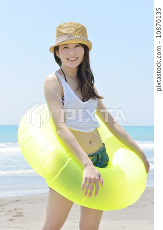 A young lady holding a float and playing at the beach 10870135