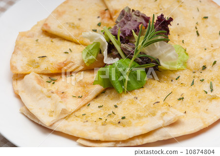 garlic pita bread pizza with salad on top 10874804