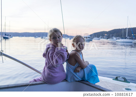 Two Caucasian girls sitting next to the sea, enjoying the sunset. Two Caucasian girls sitting next to the sea, enjoying the sunset. 10881617