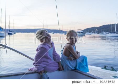 Two Caucasian girls sitting next to the sea, enjoying the sunset. Two Caucasian girls sitting next to the sea, enjoying the sunset. 10881618