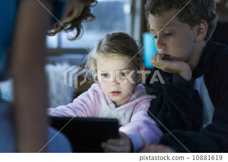 Caucasian children playing games on tablet computer Caucasian children playing games on tablet computer 10881619