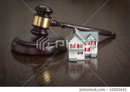 Gavel and Small Model House on Table 10883681