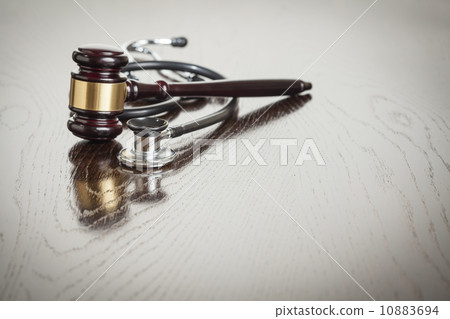 Gavel and Stethoscope on Reflective Table 10883694
