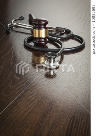 Gavel and Stethoscope on Reflective Table 10883695