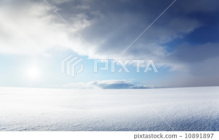 field of snow and cloudy sky 10891897
