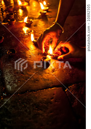People burning oil lamps as religious ritual in Hindu temple 10892505