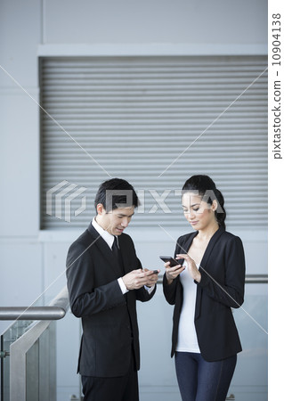 Two Asian business colleagues using smartphone's. Two Asian business colleagues using smartphone's. 10904138