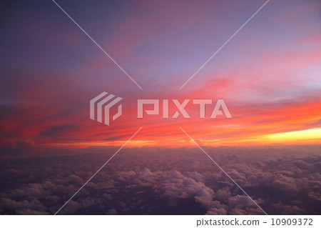 Clouds that occurred on the Pacific Ocean are lit by the setting sun and stained red. 10909372